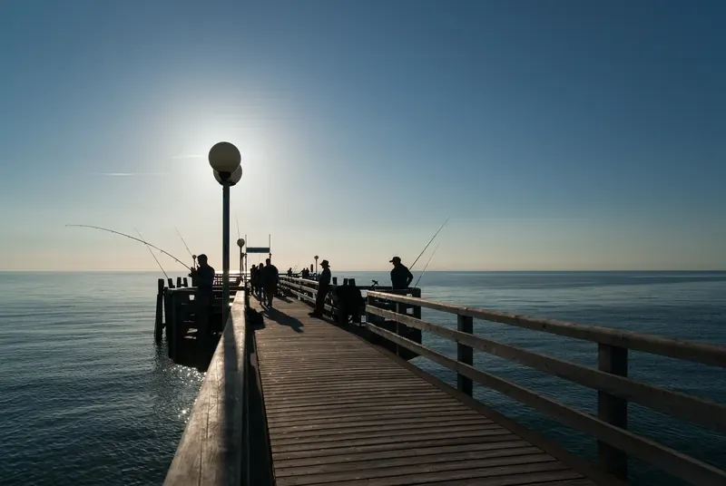 Angler auf der Seebrücke Wustrow an der Ostsee im Gegenlicht